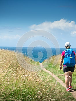 Girl with backpack travels along sea