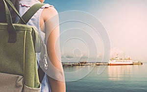 Girl with backpack waiting for a cruise ship at sea port.
