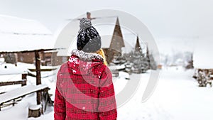 Girl backs in winter snow street walk outdoor countryside, walk alone travel, cold weather, woman red jacket clothes