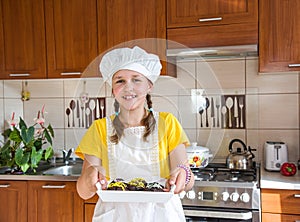 A girl baked a cupcake in her kitchen