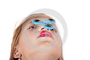 Girl balancing a fidget spinner on her nose