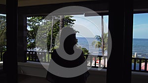 Girl on the balcony of the hotel looks at the sea