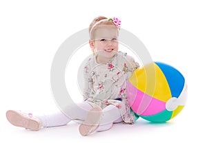 The girl with the ball sitting on white background