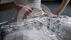 Girl ballerina touches tutu, sitting on floor, preparation for dance, ballet concept