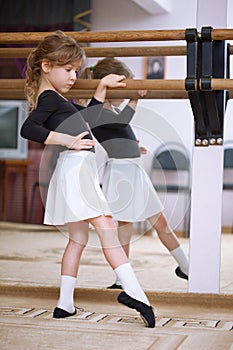 Girl at ballet barre. Ballet pas photo