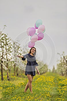 girl with balloons in the field