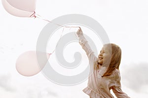 Girl with balloons in park.