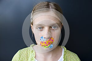 Girl with bandages over her mouth photo