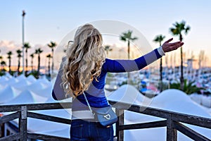 Girl in the Barcelona Port at sunset. Vintage city portrait of young stylish blonde woman having fun, travel alone