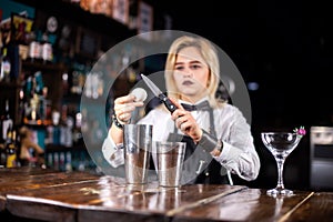 Girl barman formulates a cocktail in the taproom