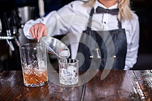 Girl barman makes a cocktail in the beerhouse