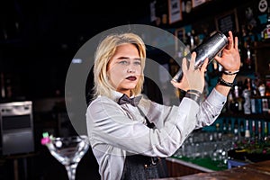 Girl barman mixes a cocktail in the beerhouse
