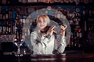 Girl barman mixes a cocktail in the taproom