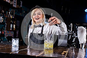 Girl bartender concocts a cocktail at the saloon