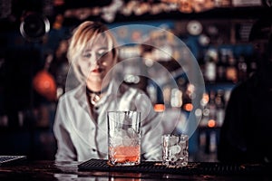 Girl bartender mixes a cocktail at the alehouse