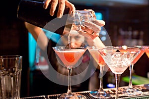 The girl bartender prepares a cocktail in the nightclub