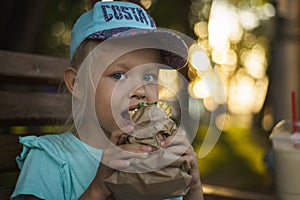 Girl in a baseball cap eating