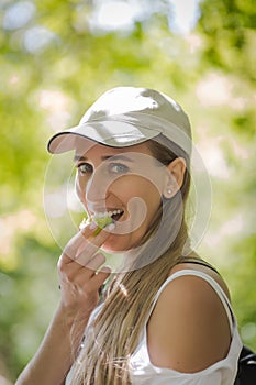 Girl in baseball cap eats apple