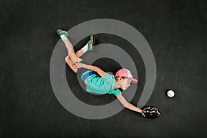 Girl baseball player making a diving catch