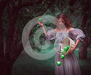 A girl with a basket with apples in a fairy forest