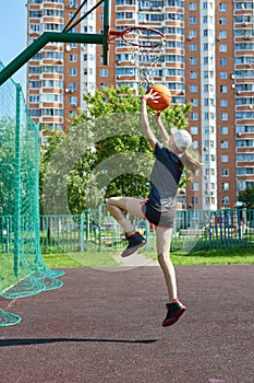 Girl basketball player throws ball in basket