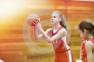 Girl basketball player throws ball in game