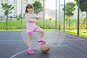 Girl with a basketball on the playground. Healthy lifestyle and sport concepts