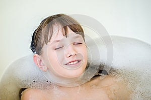 The girl bathes in a bathroom with foam and the closed eyes.