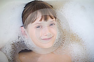 The girl bathes in a bathroom and smiles