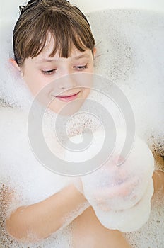 The girl bathes in a bathroom and smiles