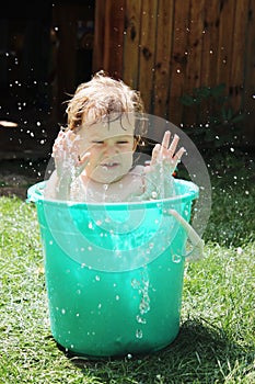 Girl bathes in a bucket