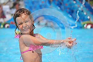 Girl bathes in pool under water splashes photo