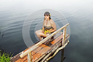 Girl in a bathing suit with a bunch of water lilies