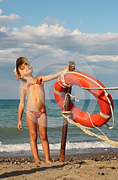 Girl in bathing suit and cap standing on beach