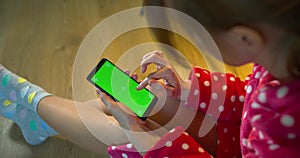Girl in a bathrobe uses a phone with a green screen trackers
