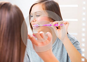 Girl in the bathroom brushing teeth