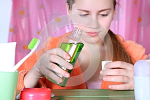 Girl in bathroom pouring mouthwash