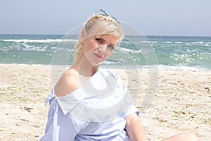 The girl on the beach, the blonde by the sea. Girl in blue dress