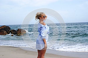 The girl on the beach, the blonde by the sea. Girl in blue dress