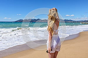 Girl at the beach in Cannes, France. Beautiful Seaside background. Back view