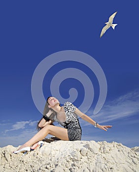 Girl on the beach and flying gull