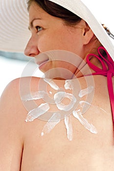 Girl on the beach with narisovanna shoulder sun protection cream