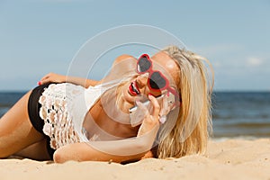 Girl on beach with phone.