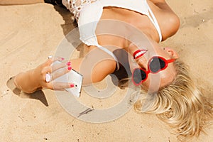 Girl on beach with phone.