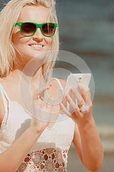 Girl on beach with phone.