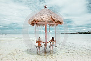 Girl on beach swing on Bali island