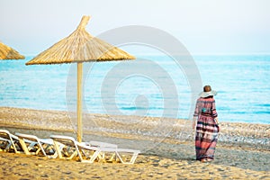 Girl on a beach, under an beach umbrella