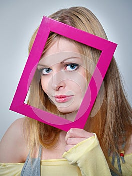 Girl with beautiful eyes holds a pink framework at