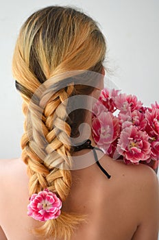 A girl with a beautiful hairdress with a bouquet of tulips is a sort of Columbus