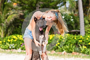 The girl beautiful in jeans shorts and an undershirt also gatsya with dogs, game with dogs on the beach.